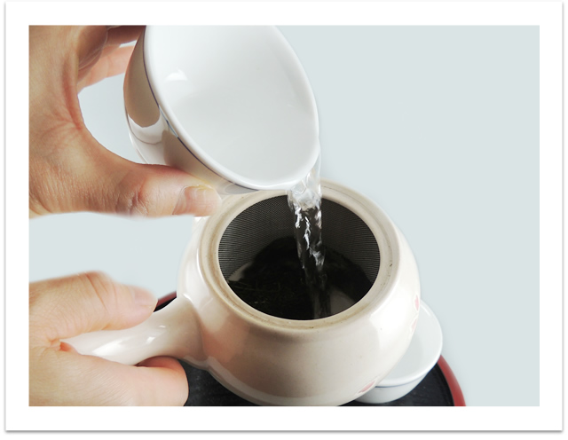 Pour the water from the tea cups into the kyusu.